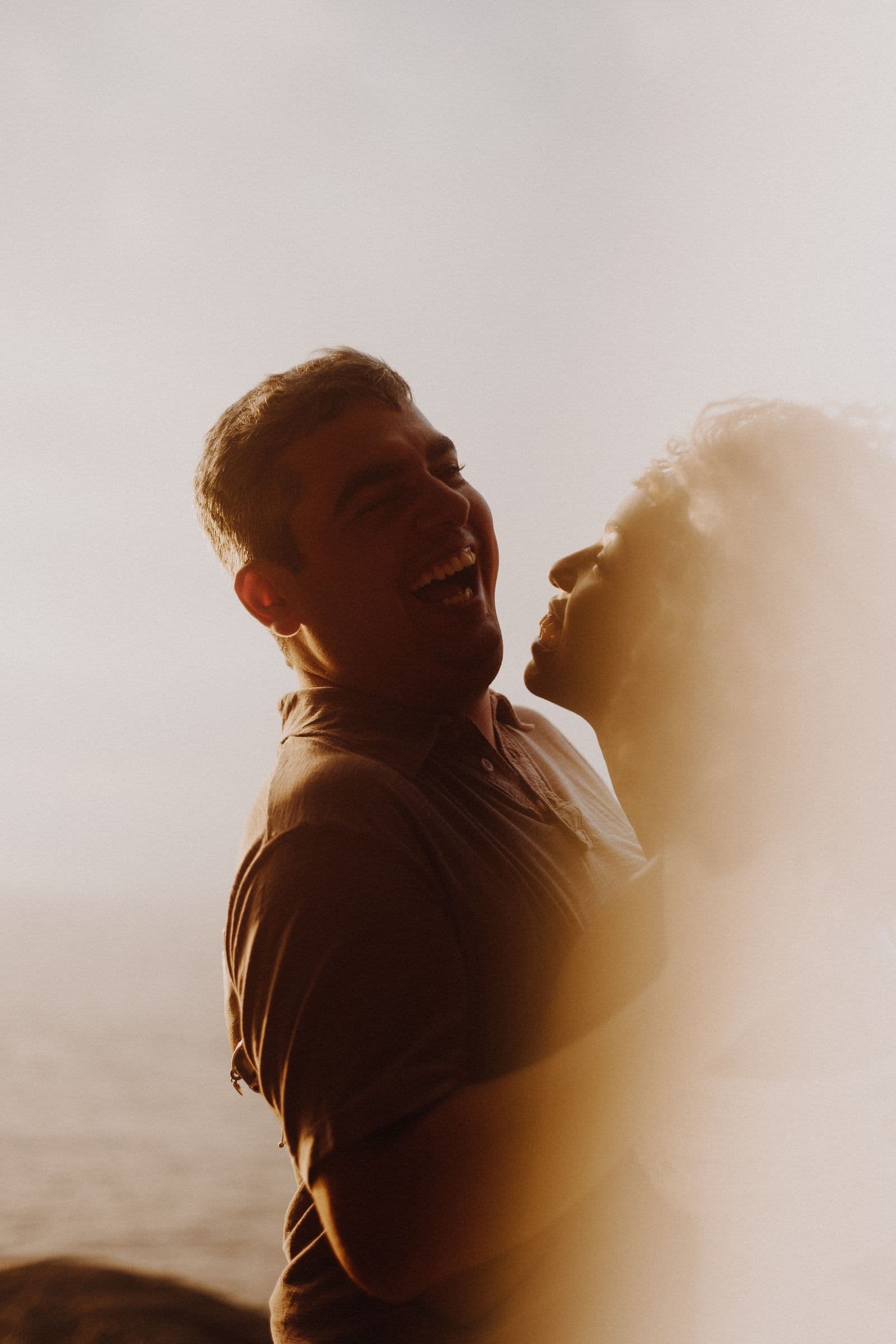 A couple laughing together by the sea