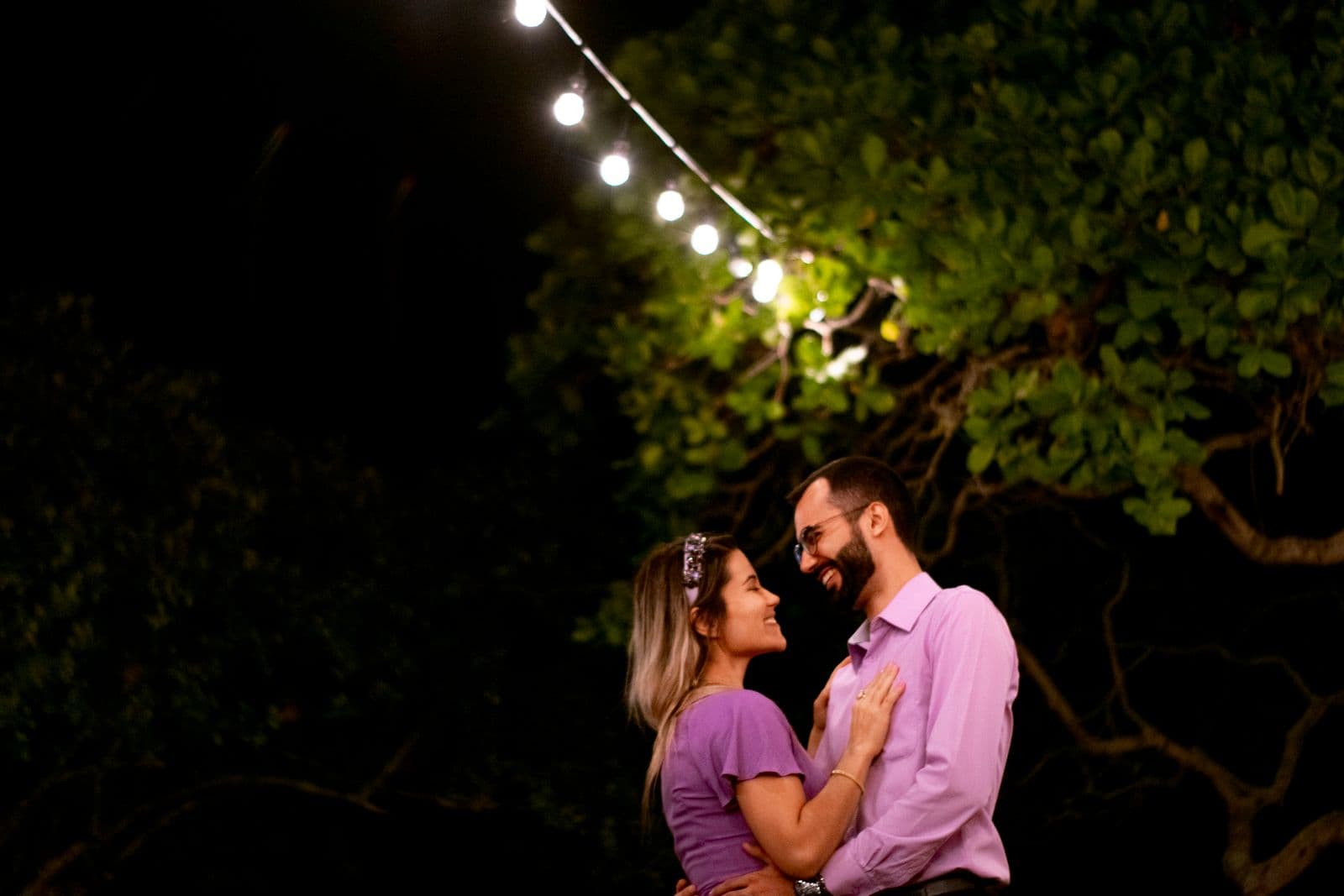 Profile preview of a smiling woman under string lights